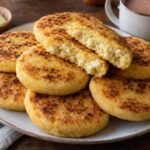 Arepas boyacenses gruesas y doradas con queso campesino, una de ellas abierta para mostrar el centro tierno