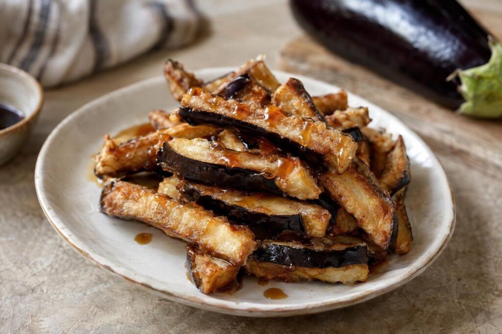 Berenjenas fritas con miel de palma, doradas y crujientes, servidas en un plato