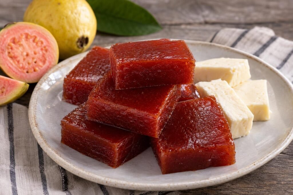 Cubos firmes de bocadillo veleño colombiano de guayaba servidos junto a queso blanco.