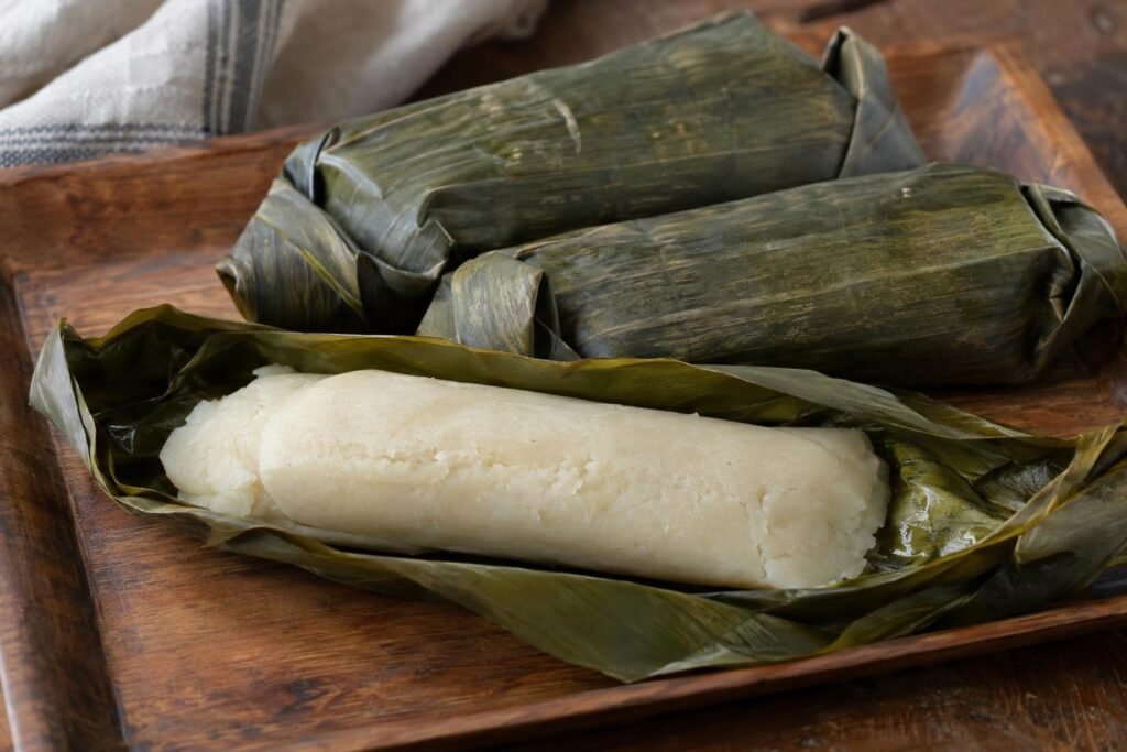 Bollos limpios colombianos de masa de maíz blanco cocidos al vapor y envueltos en hojas de plátano.