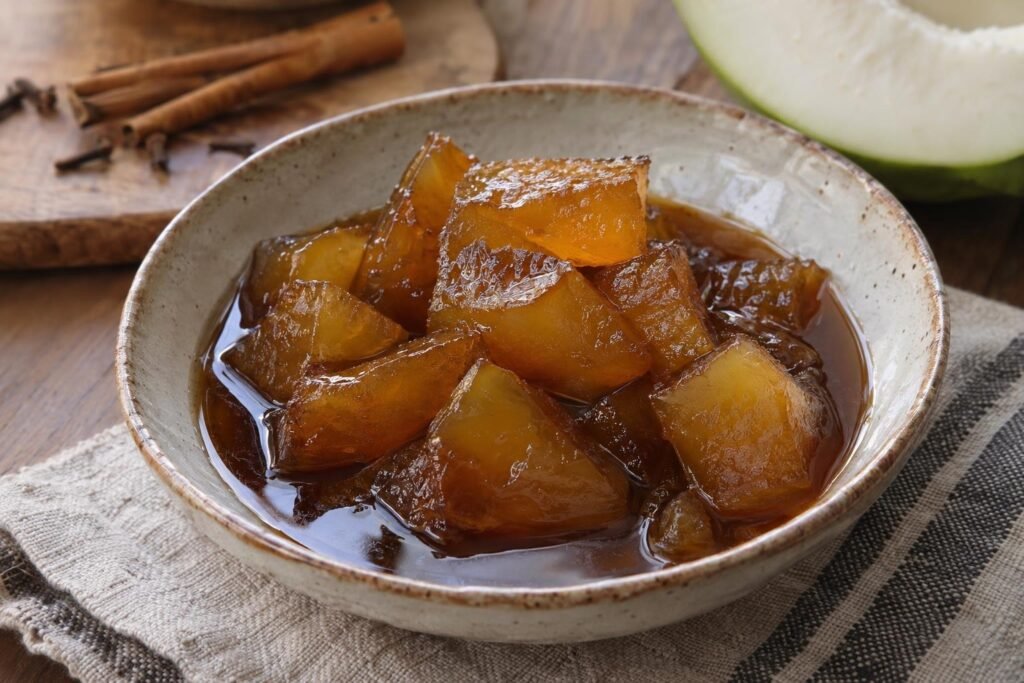 Dulce de cidra colombiano en trozos tiernos con almíbar brillante de panela y canela servido en un plato pequeño.