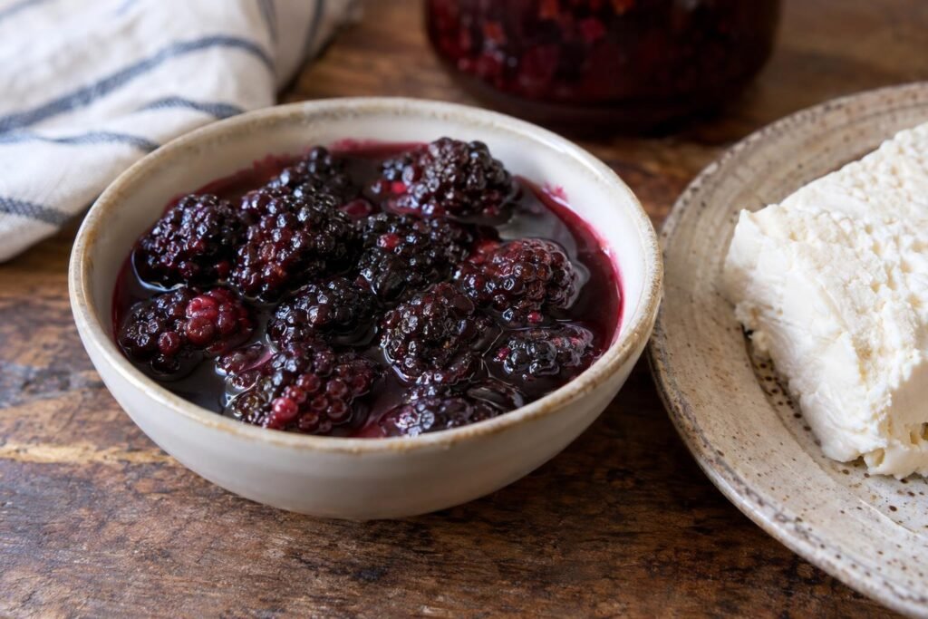 Dulce de mora colombiano con moras enteras en almíbar brillante servido junto a queso fresco