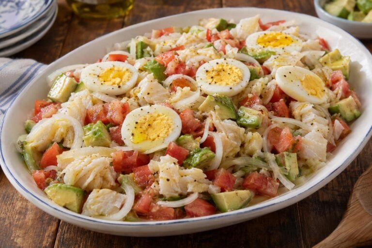 Ensalada puertorriqueña de bacalao con tomate, cebolla, aguacate y rodajas de huevo cocido