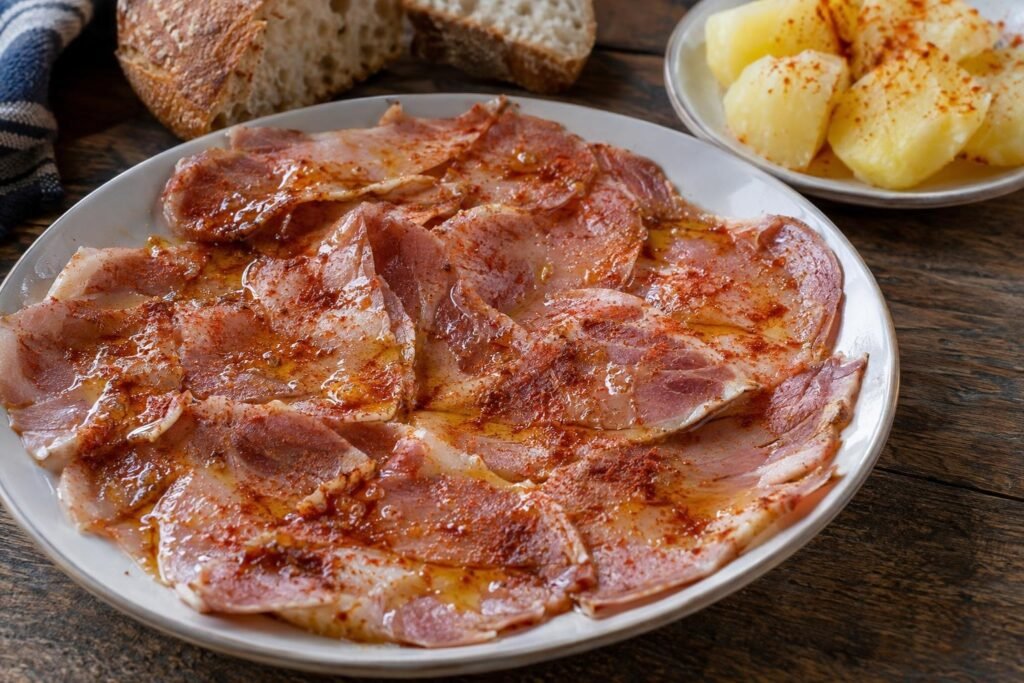 Lonchas tiernas de lacón gallego con pimentón de la Vera y aceite de oliva, servidas con pan y patatas cocidas