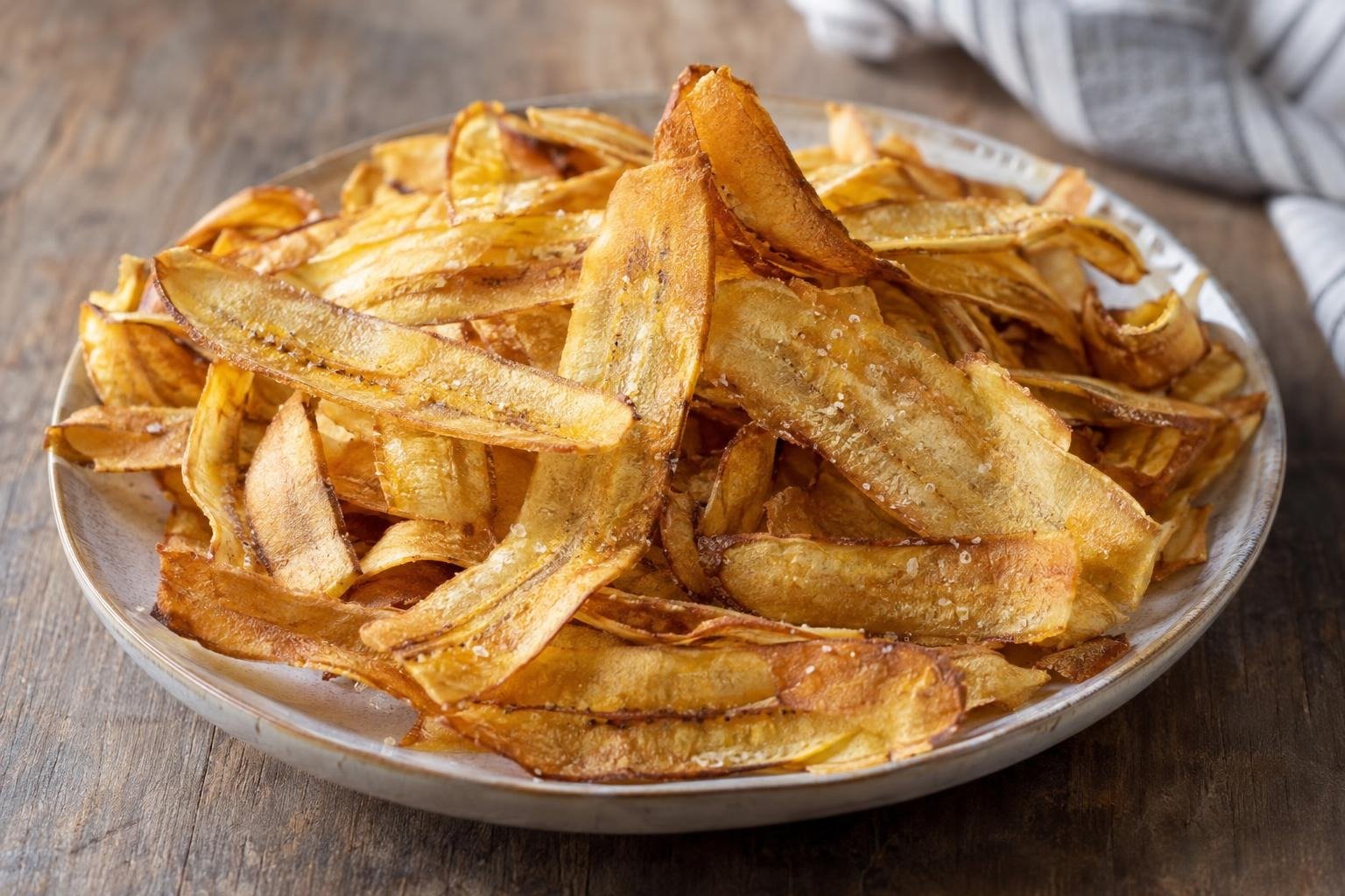 Mariquitas de plátano cubanas, láminas finas de plátano verde fritas hasta quedar doradas y crujientes, servidas con sal.