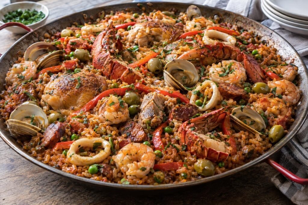 Paella al estilo panameño con arroz, pollo, cerdo, chorizos, camarones, almejas, calamares y langosta en una paellera amplia.