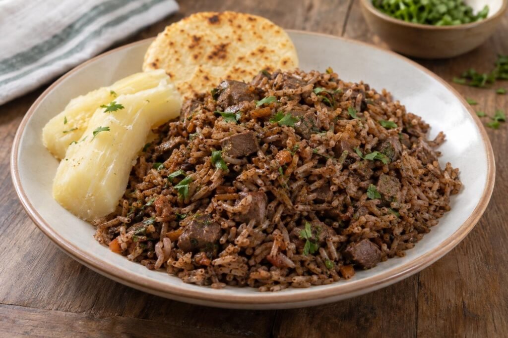 Porción de pepitoria santandereana con arroz oscuro, vísceras de cabro picadas y cilantro, acompañada de yuca y arepa.