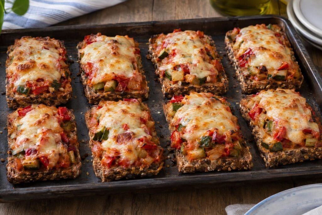 Tostadas de pan de semillas con verduras rehogadas y queso fundido gratinado